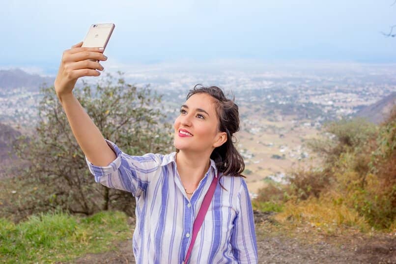 femme prenant une photo avec son portable